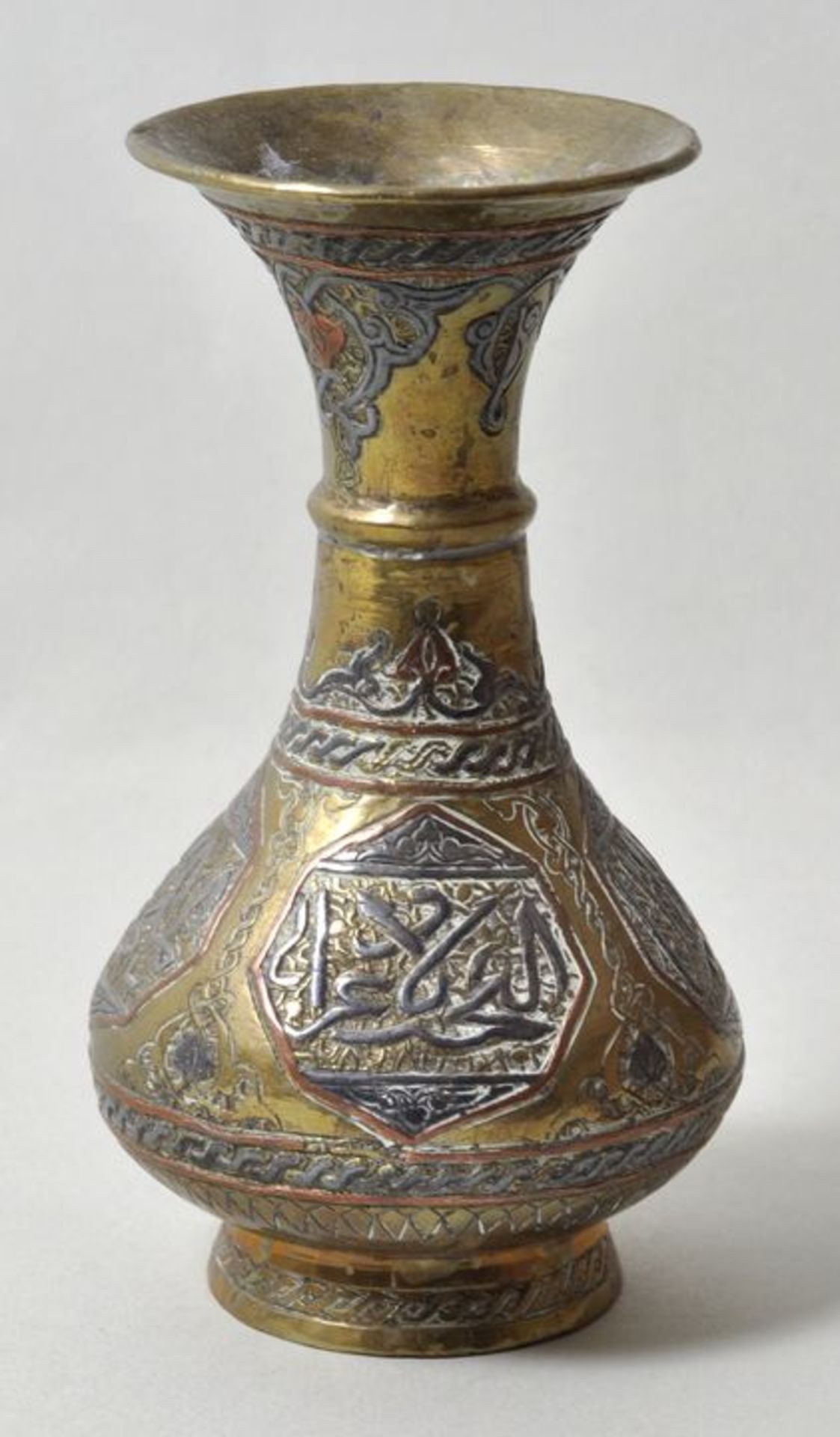 Persien. Kleine Vase.Messing, ornamental verziert, partiell farbig gefasst. Wohl 20. Jh. H. 13 cm.
