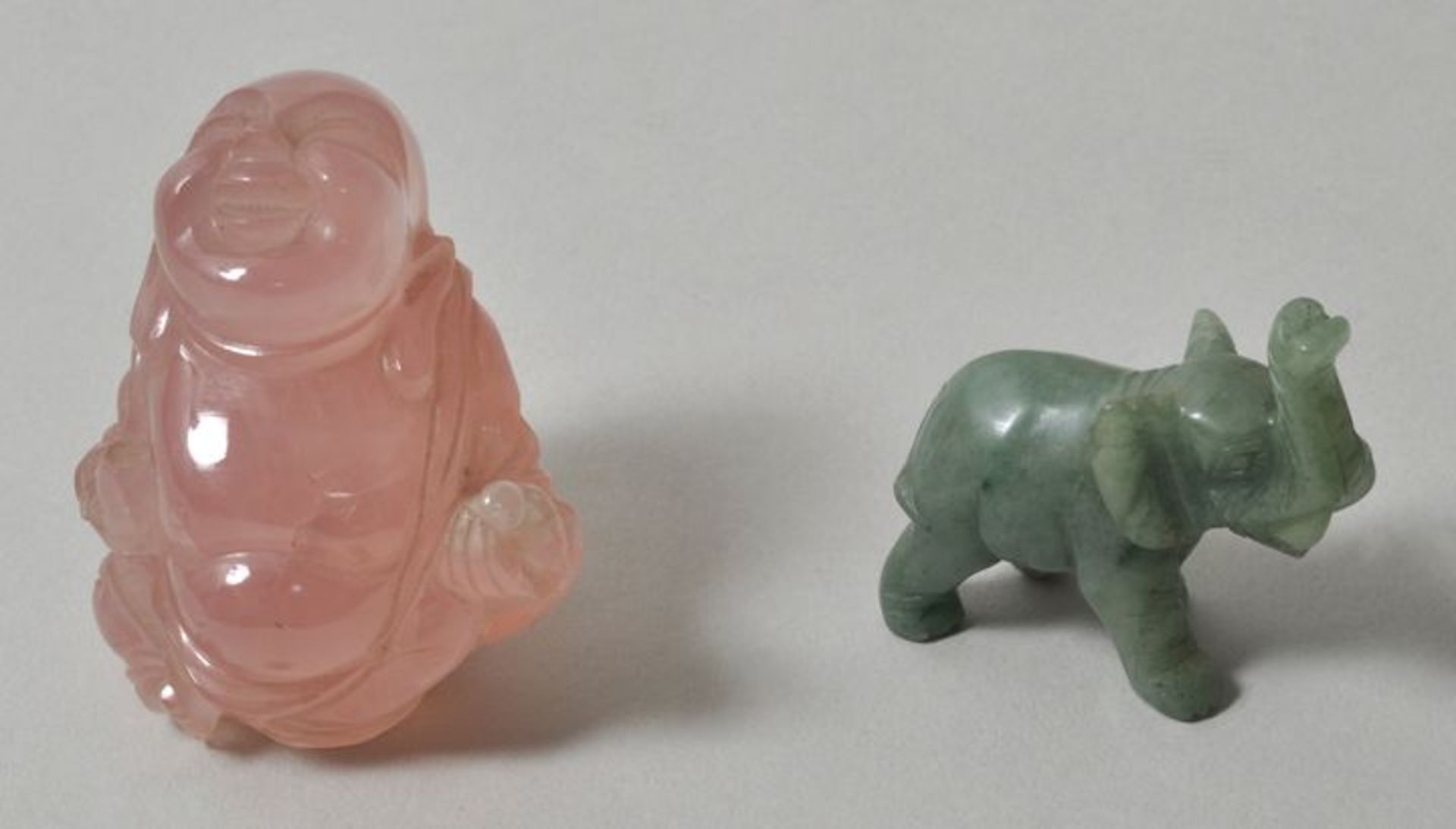 Zwei kleine Steinschnitzereien, u.a. China, 20. Jh.a) lachender Buddha/ Hotei, Rosenquarz, H. 55 mm;