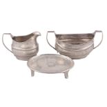 A George III Irish silver tea pot stand, sugar basin and milk jug by Robert Breading, Dublin 1805