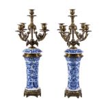 A pair of Continental blue and white glazed porcelain and brass mounted five light candelabra, early