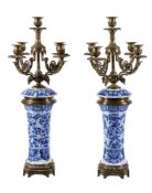 A pair of Continental blue and white glazed porcelain and brass mounted five light candelabra, early