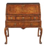 A Queen Anne or George I walnut and feather banded bureau