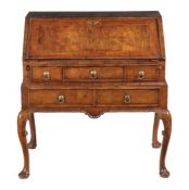 A Queen Anne or George I walnut and feather banded bureau