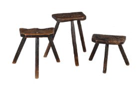 Three rough hewn oak stools, possibly milking stools, 17th century