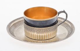 A French silver and porcelain cup and saucer by Henin & Cie.