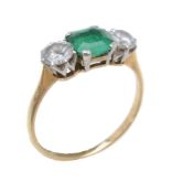 An emerald and diamond three stone ring