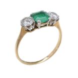 An emerald and diamond three stone ring