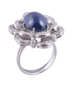 A sapphire and diamond ring, the central oval cabochon sapphire, estimated to weigh 8.71 carats claw