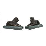 A pair of patinated bronze and marble mounted models of recumbent lions