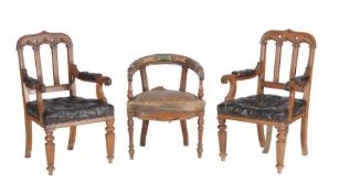 A pair of Gothic Revival oak and leather upholstered armchairs