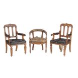 A pair of Gothic Revival oak and leather upholstered armchairs