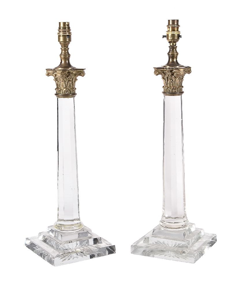 A pair of gilt metal mounted moulded and cut glass columnar table lamps