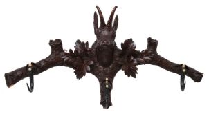 A set of carved and stained wood and horn mounted wall hanging hooks in Black Forest style