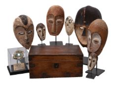 A group of seven carved and painted wood masks in the style of antique African tribal examples
