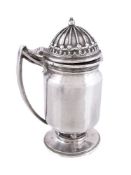 An Arts and Crafts hammered silver mustard pot by Omar Ramsden