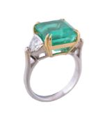 An emerald and diamond three stone ring