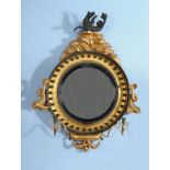 A Regency carved giltwood and composition convex wall mirror
