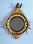 A Regency carved giltwood and composition convex wall mirror