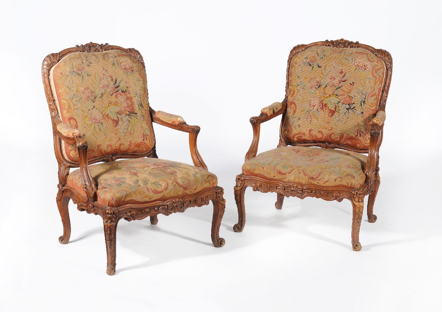 A pair of carved walnut and needlework upholstered armchairs