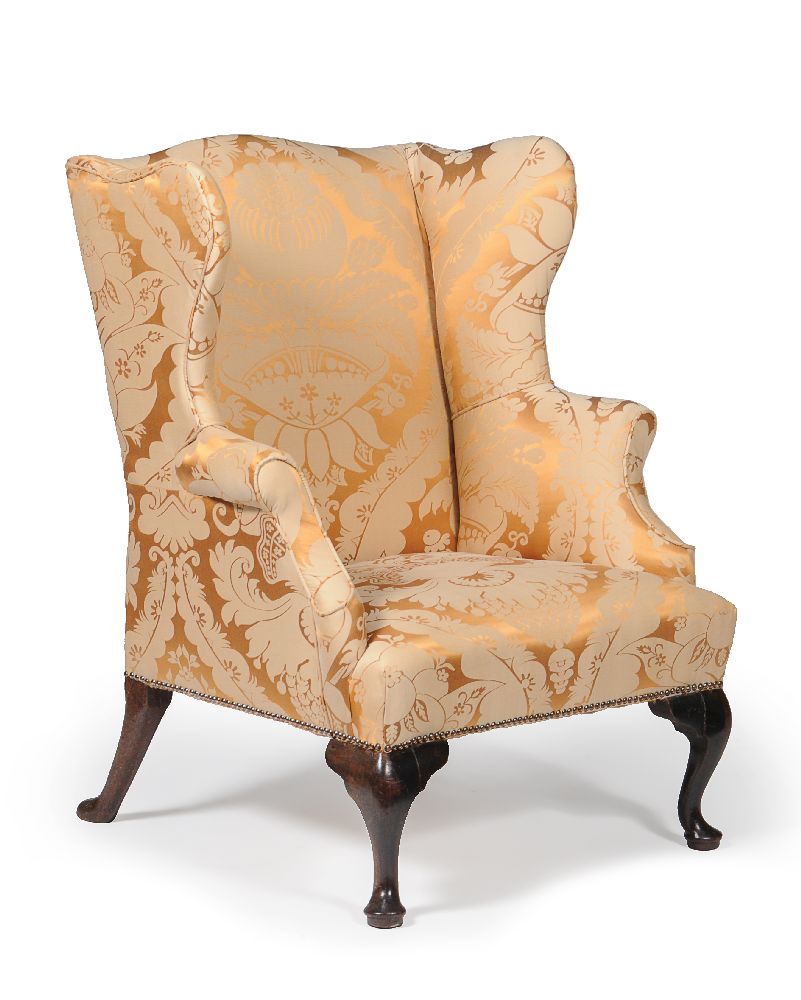 A George II walnut and upholstered wing armchair