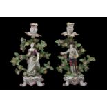 A pair of Bow figural candlesticks of a gardener and companion, circa 1765, modelled on scroll bases