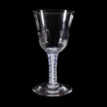 An opaque-twist wine glass, circa 1760, the round funnel bowl with a hammered flute basal section,