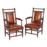 A pair of Reformed Gothic walnut and leather upholstered armchairs, circa 1870, in the manner of