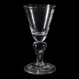 A baluster wine glass, first quarter 18th century, the round funnel bowl with solid basal section