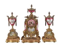 A gilt spelter and claret Sevres style porcelain clock garniture