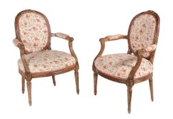 A pair of carved walnut and later upholstered fauteuils in Louis XVI style, 19th century