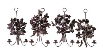 A set of four Italian wrought, pressed and painted metal twin light wall appliques