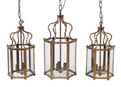 A pair of gilt metal and glazed three-light hexagonal hall lanterns in George III style