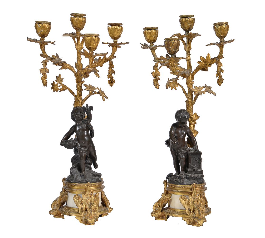 A pair of gilt and patinated metal and white marble mounted four light figural candelabra
