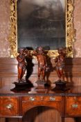 A pair of carved mahogany putti