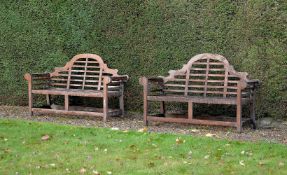 A pair of teak garden seats in the manner of designs by Lutyens