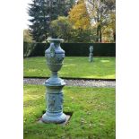 A pair of painted lead twin handled urns and pedestals