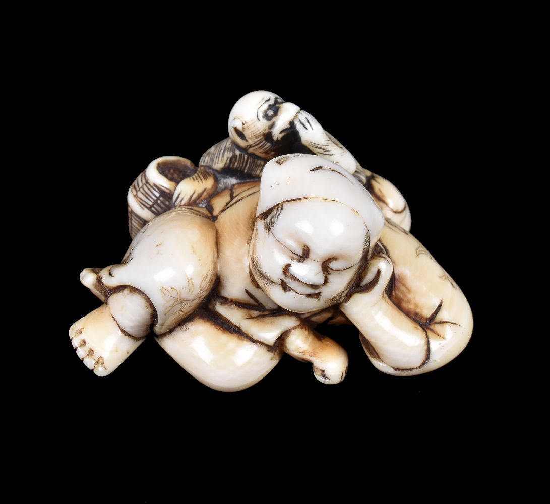 ϒ A Japanese carved Ivory Netsuke of a reclining sarumawashi dressed in typical garb and asleep