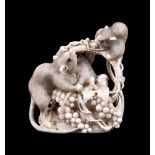 ϒ A Japanese Ivory Okimono carved to depict a woven basket overflowing with grapes