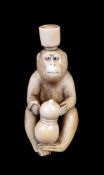 ϒ SHUGYOKU: A Japanese Ivory Netsuke carved as a monkey seated gripping a double-gourd
