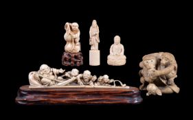 ϒ A Japanese Ivory Okimono depicting Hotei reclining against his treasure sack