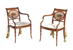 A pair of Sheraton Revival satinwood and polychrome painted elbow chairs