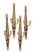 A set of four parcel gilt and painted metal twin light wall appliques in Empire taste