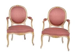 A pair of cream painted and parcel gilt armchairs
