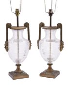 A pair of clear glass and gilt metal mounted table lamps in Neoclassical taste