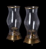 A pair of baluster glass and brass mounted storm lanterns