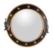 A black painted and giltwood convex wall mirror