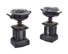 A pair of Victorian patinated and parcel gilt bronze and marble mounted models of urns on plinths in