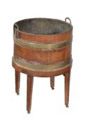 A George III mahogany and brass bound circular wine cooler or jardinière