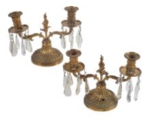 A pair of gilt bronze and cut glass hung twin light lustre candelabra in Louis XV/Louis XVI transiti