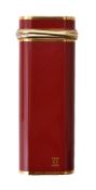 Cartier, Must de Cartier, a red enamelled and gilt metal lighter